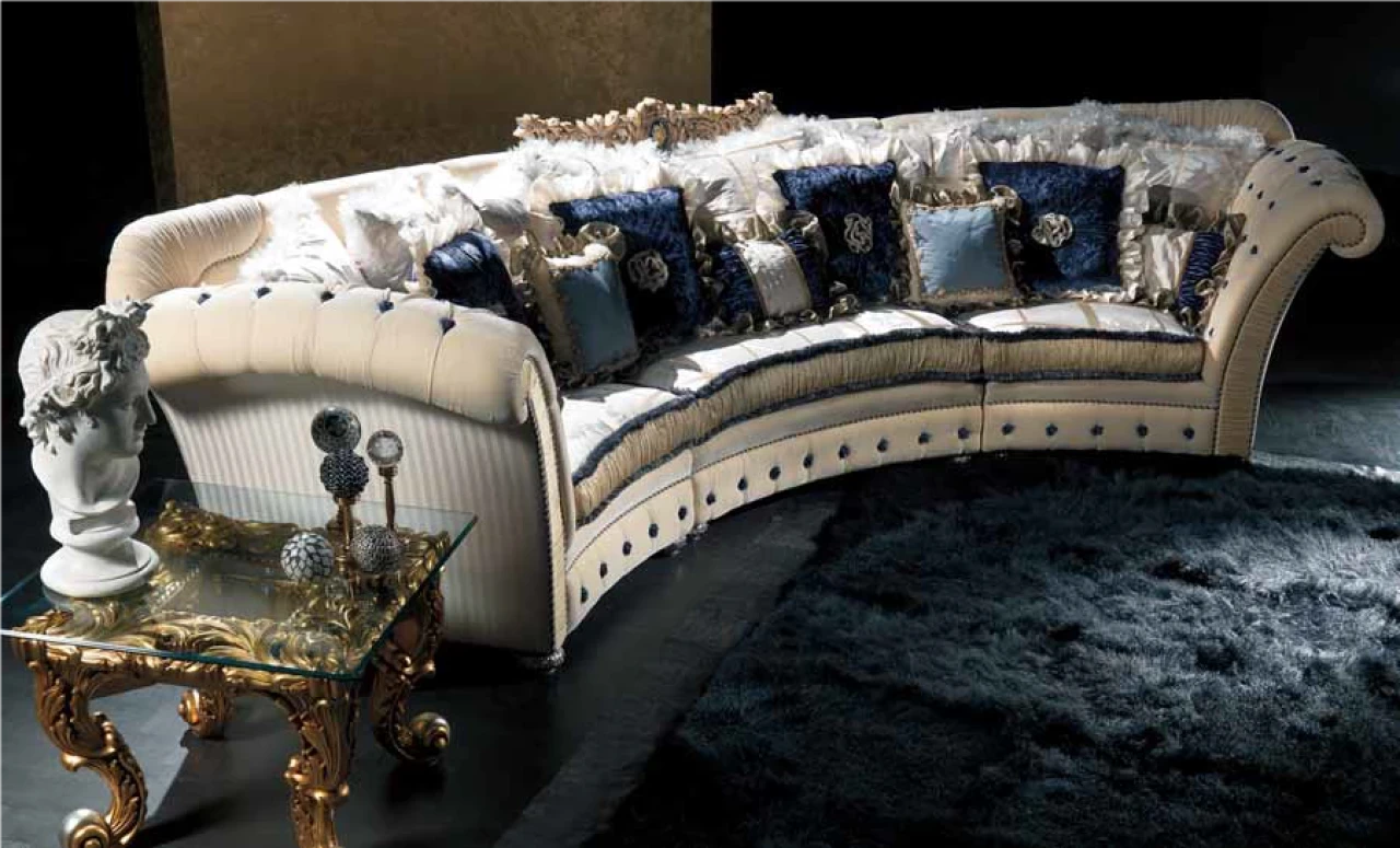 Curved cream sofa with tufted back and blue scatter cushions, luxury living furniture